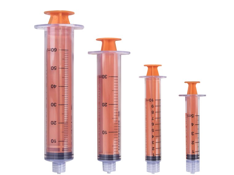 TwistLok Enteral Syringe group. Various sizes of TwistLok syringes with plungers pushed down.