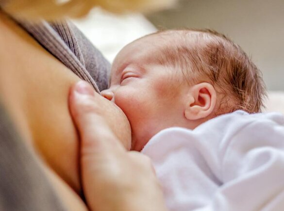 Close-up of a mom breastfeeding her newborn baby.