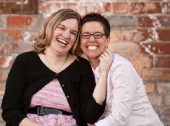 A smiling couple sitting outside.