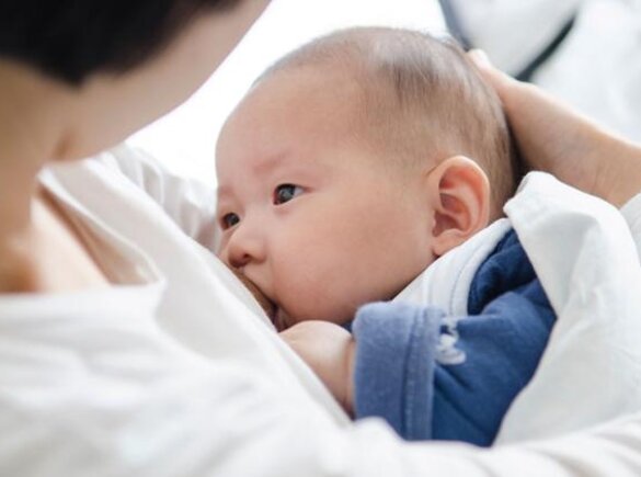 A mother cradles her baby while breastfeeding.