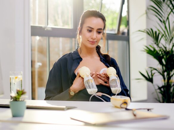 A mother using a Medela Freestyle™ Hands-free electric double breast pump at work.