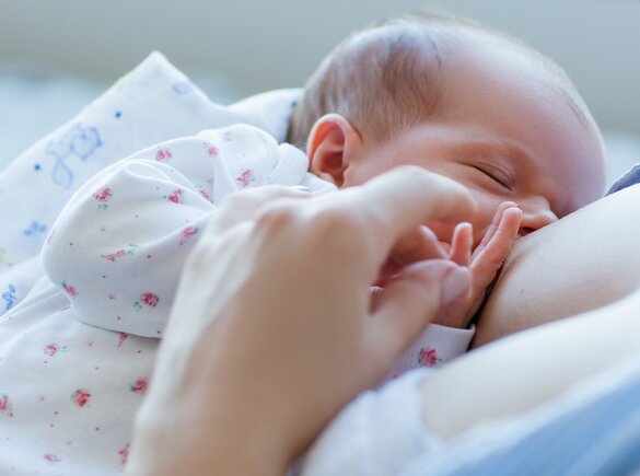 A close-up of a mom breastfeeding her baby-girl.