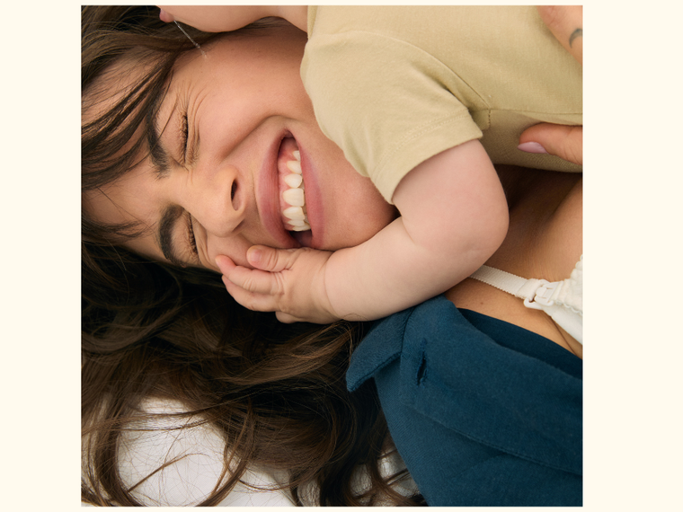 A mom smiling while receiving cuddles from her toddler A mom smiling while receiving cuddles from her toddler