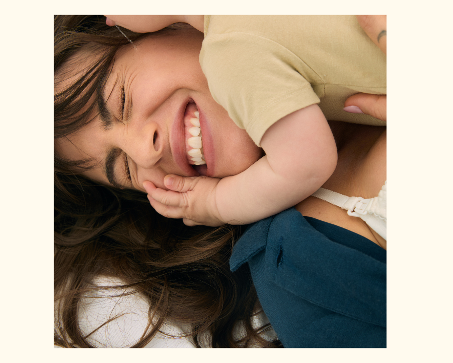 A mom smiling while receiving cuddles from her toddler A mom smiling while receiving cuddles from her toddler