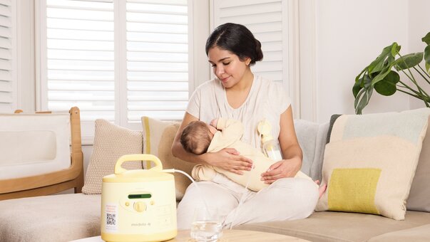 mum breastfeeding her baby while using symphony breast pump