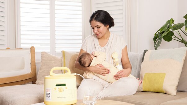 Mum, die ihr Baby mit einer gemieteten Medela Symphony PLUS® Milchpumpe stillt