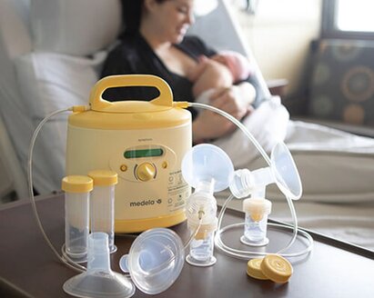 Medela Symphony® breast pump and breast milk initiation kit with Mom and baby in hospital room in background