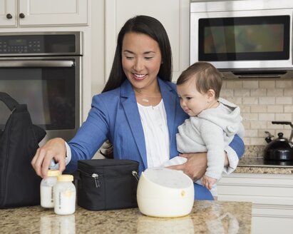 Working Mom packing up her Medela Sonata® breast pump and Cooler Bag with filled breast milk storage bottles