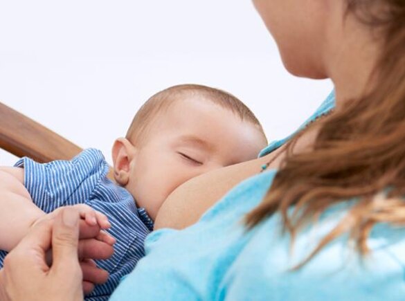 Breastfeeding Tips A baby falls asleep while being breastfed in his mother's arms as she sits in a rocking chair.