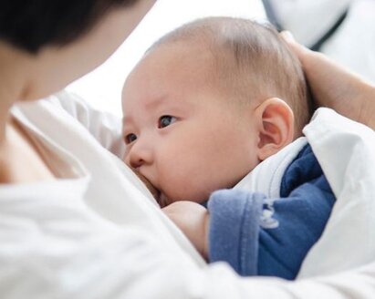 A mother comforting their baby during the baby's first cold, with tips and remedies from Medela to help provide relief and care