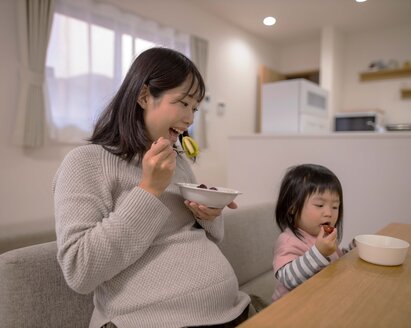 Pregnant woman enjoying a healthy meal, emphasizing the importance of nutrition during pregnancy.