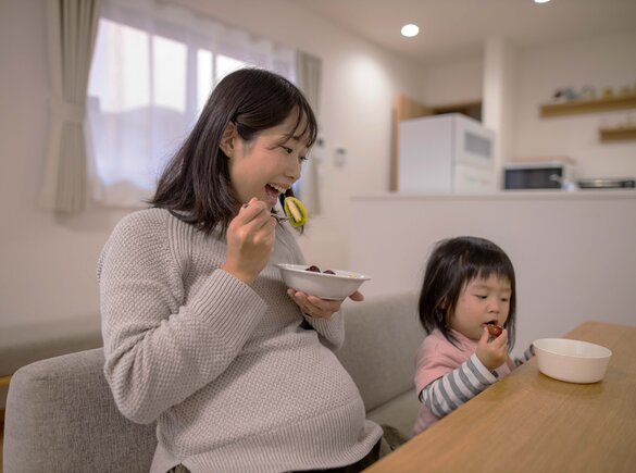 Pregnancy Preparation Pregnant woman enjoying a healthy meal, emphasizing the importance of nutrition during pregnancy.