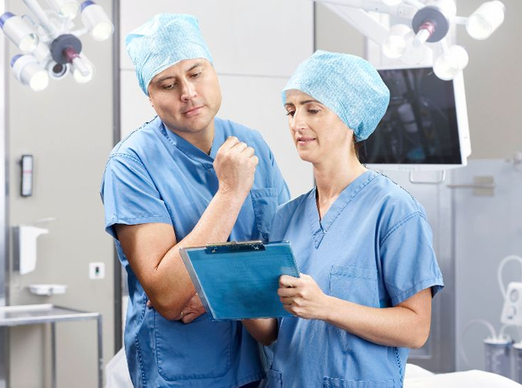 Un médecin et une infirmière discutent d'un traitement médical dans une salle d'opération.