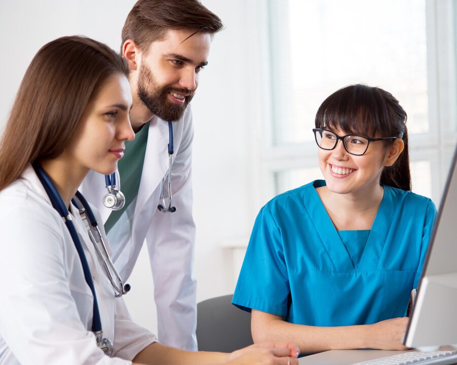 Healthcare Professionals Group of three medical professionals working together and looking at a computer screen.