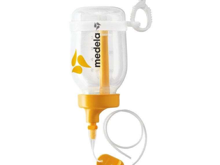 Ein zusammengebautes Supplemental Nursing System™ (SNS) mit den dazugehörigen Teilen.