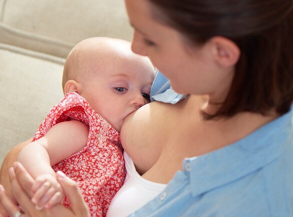 Breastfeeding A mother is at home breastfeeding her baby.