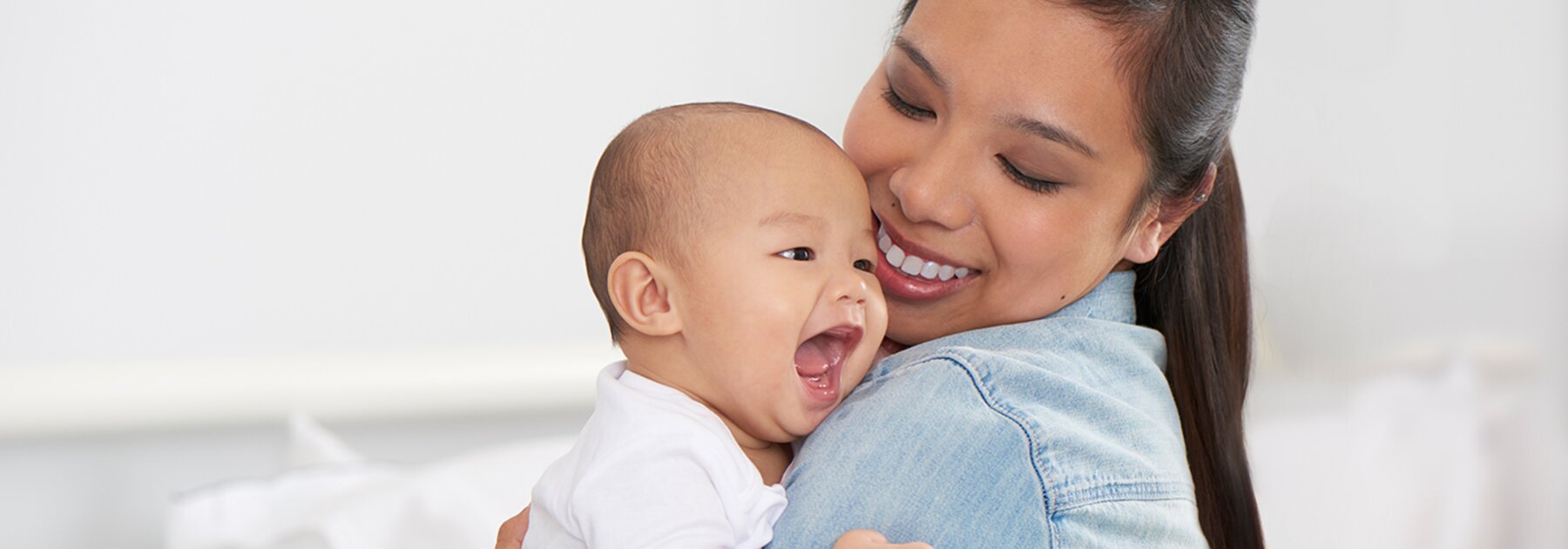 Breastfeeding Challenges A mom holds her happy baby and smiles.