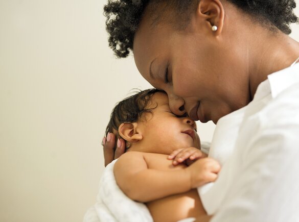 Mother holding newborn baby face-to-face.