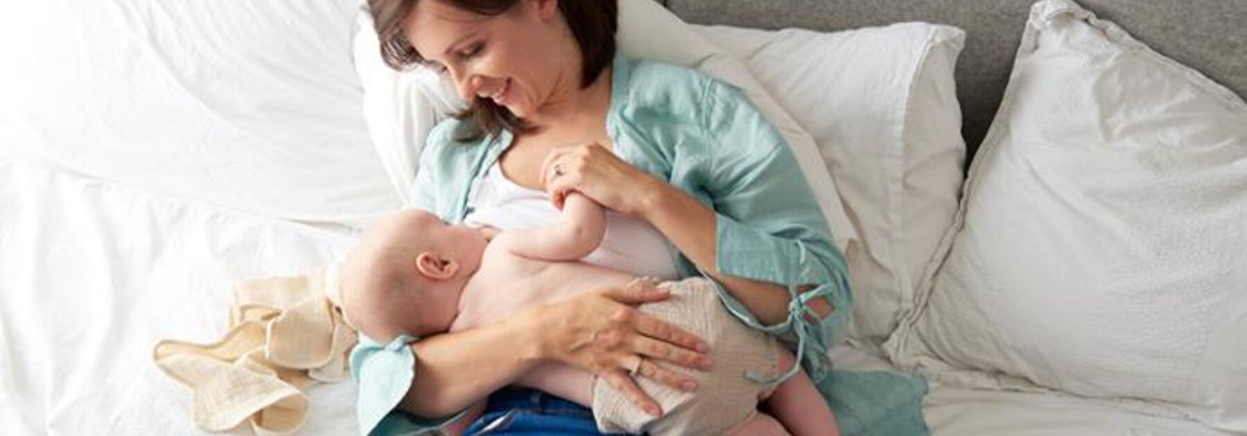 Mother breastfeeding baby in laid-back or reclined position.