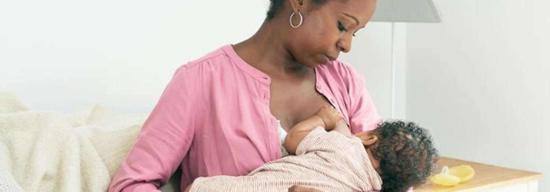 Mother breastfeeding baby in cradle hold.