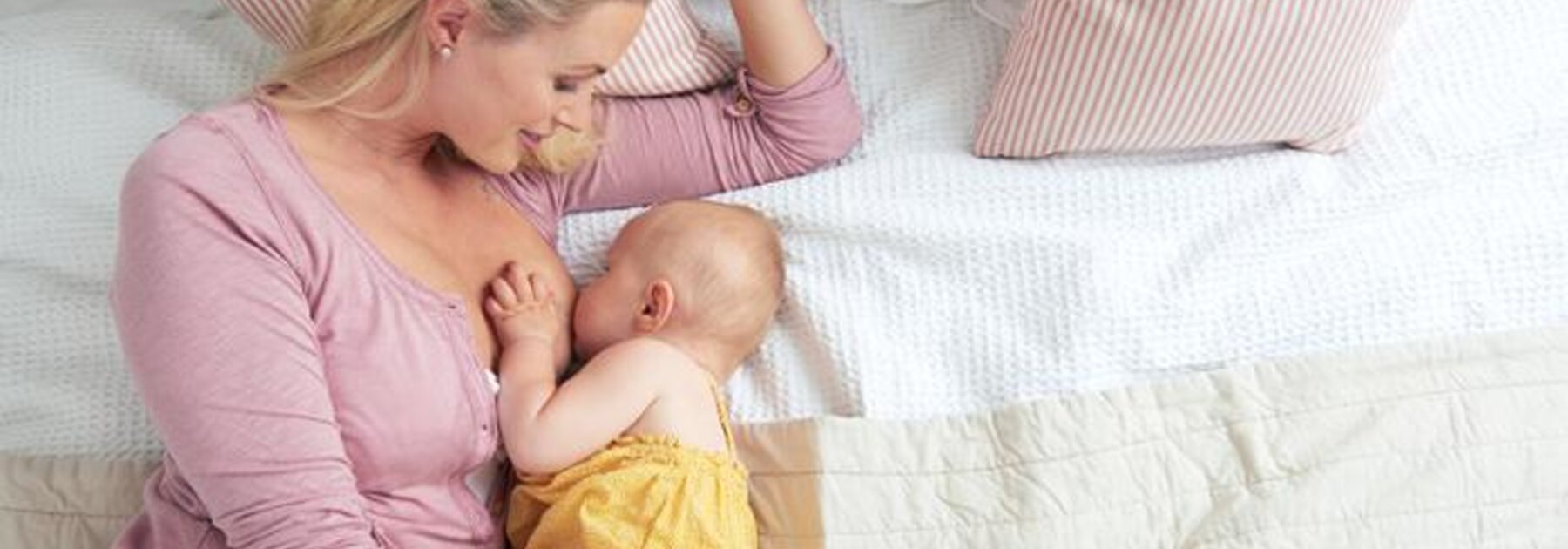 Mother breastfeeding baby in side-lying position.