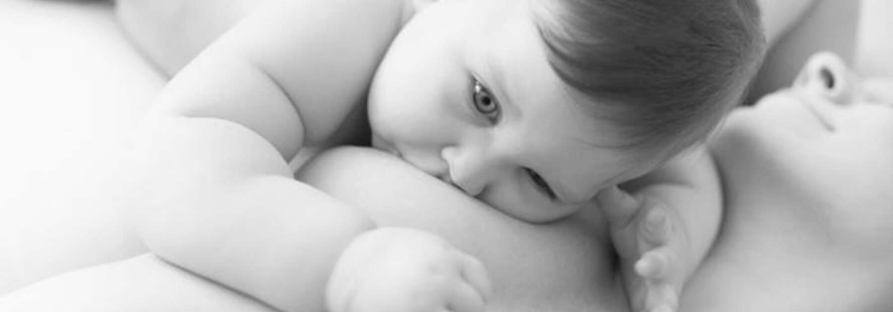 Mother breastfeeding baby in laid-back position after a caesarean delivery.