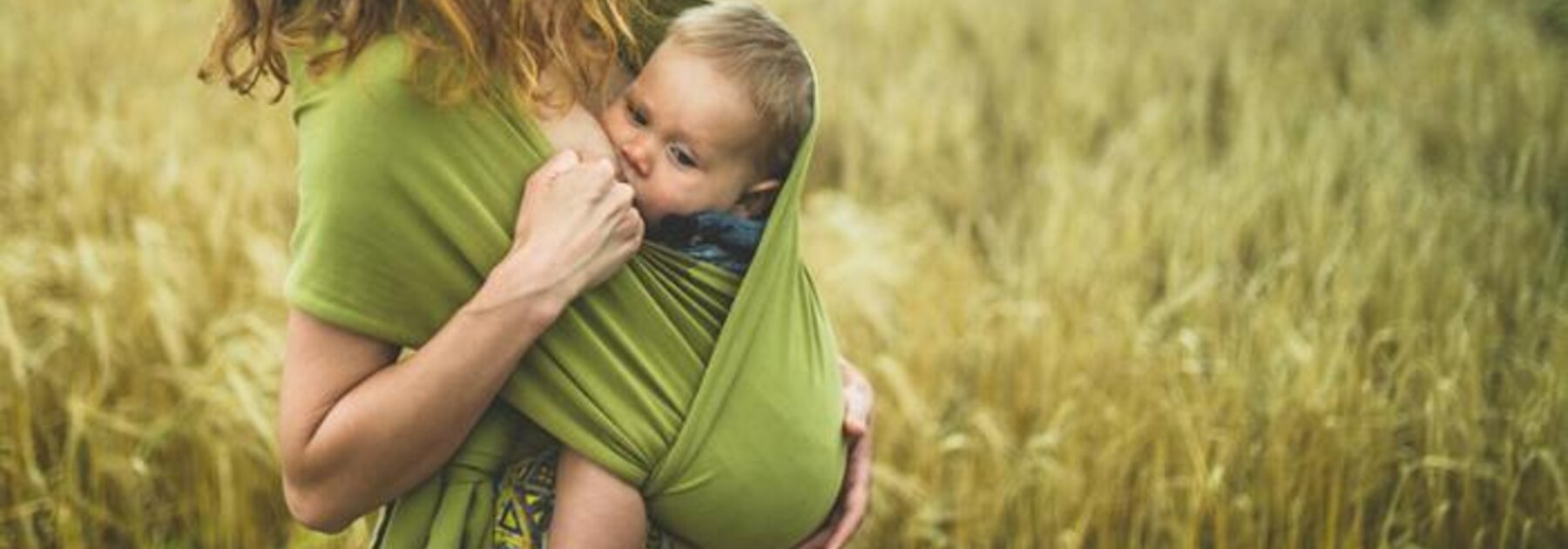 Mother breastfeeding baby in sling.